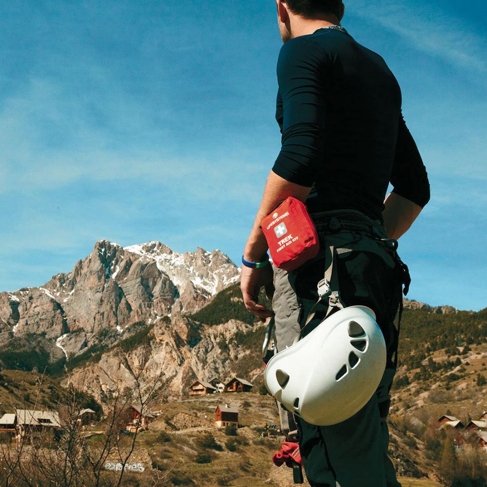 Person with climbing gear standing in a mountainous landscape