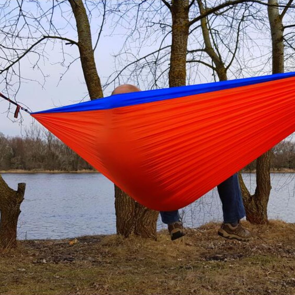 Bushmen ZEN Hammock (Orange) with person sitting in it