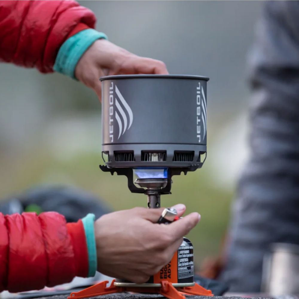 Person using a Jetboil stove in an outdoor setting