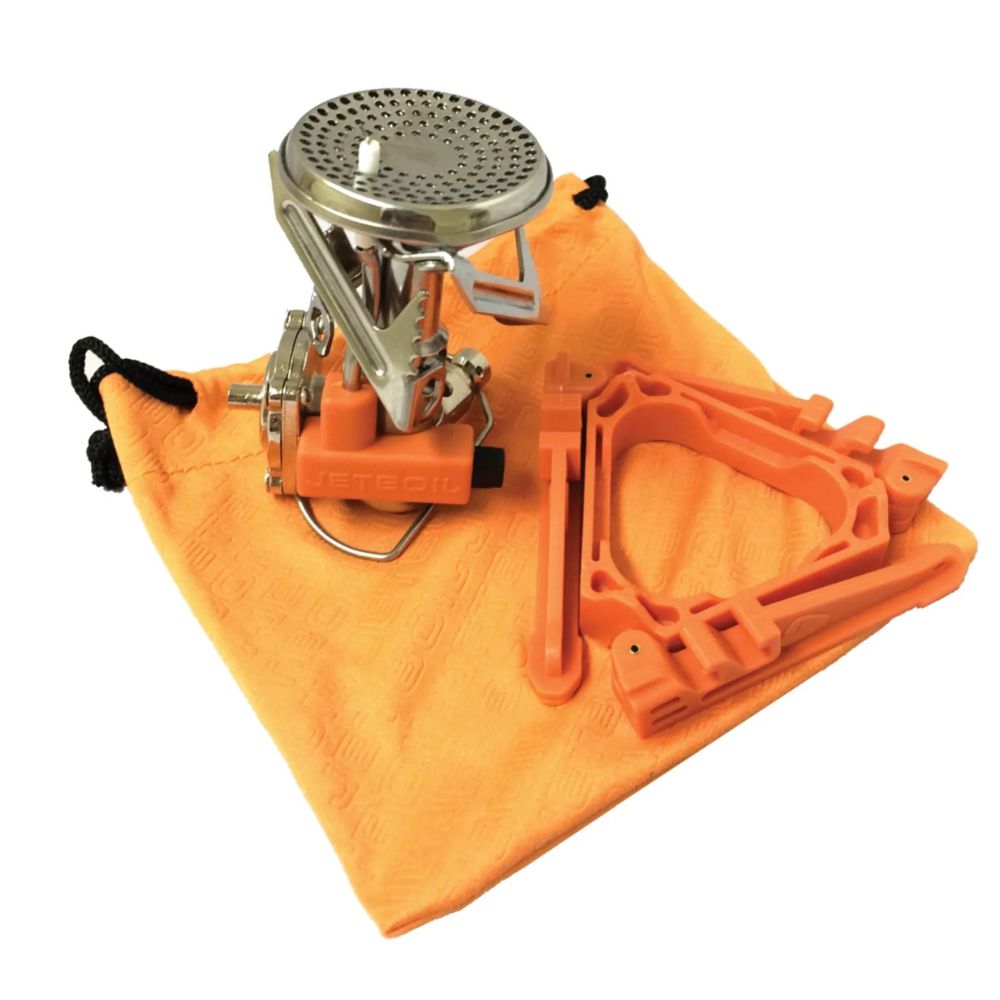 Camping stove with accessories on an orange towel