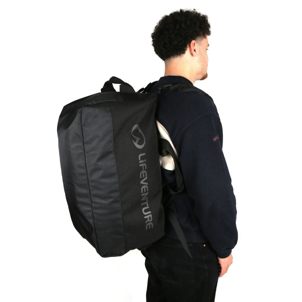 Person wearing a black Lifeventure backpack on a white background