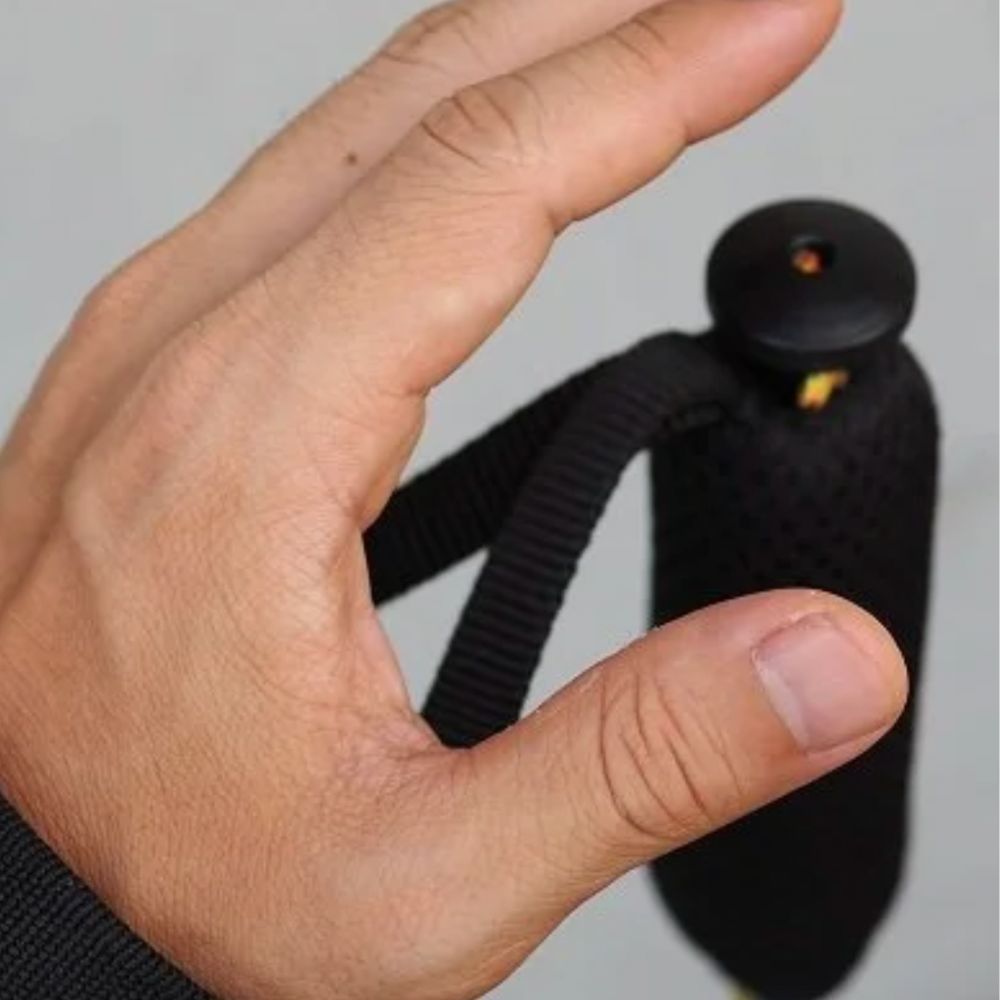 Hand holding a black lanyard against a neutral background