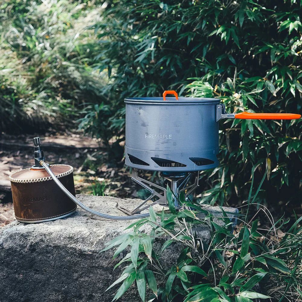 Portable camping stove with pot on a rock in a natural setting