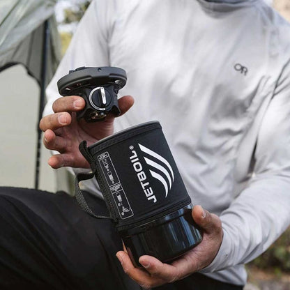 Person holding a Jetboil cooking system outdoors
