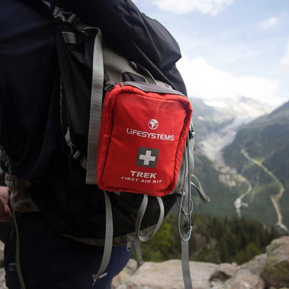 Red Lifesystems Trek First Aid Kit attached to a backpack with a mountainous landscape in the background