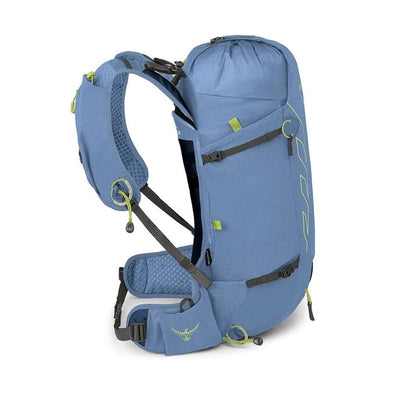 A blue Osprey backpack shown from a three-quarters angle against a plain white background, displaying its side profile, hip belt, and compression straps.