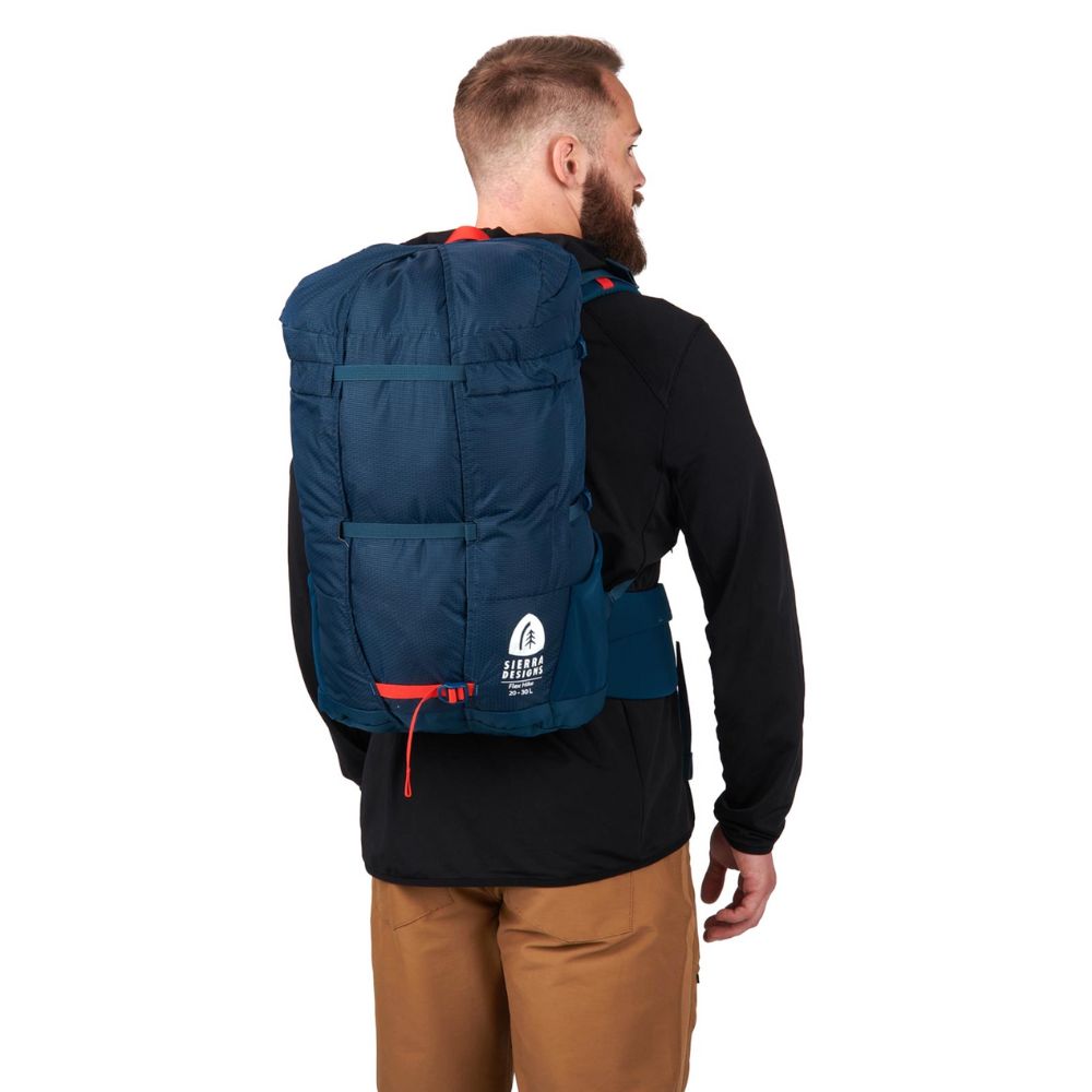 Man wearing a blue backpack with a visible brand logo on a white background