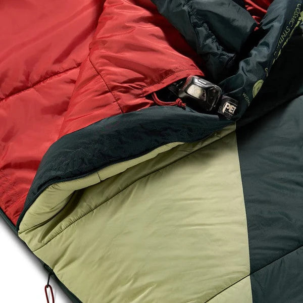 Close-up of a multicolored sleeping bag with red, black, and beige sections.